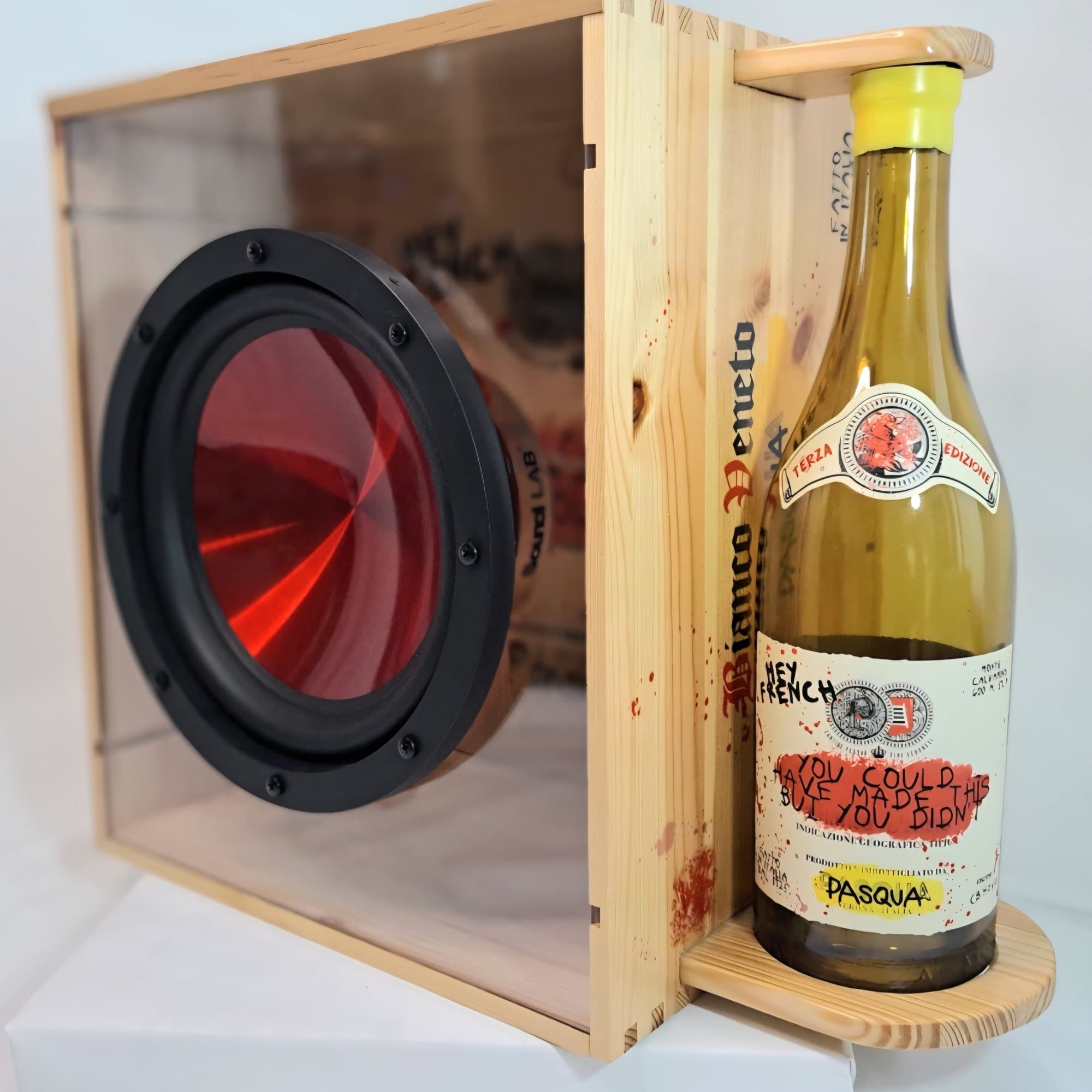 Wine box speaker with a red cone driver behind a glass front